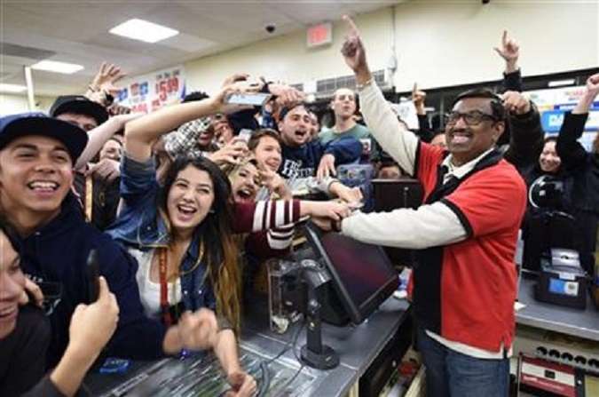 TAKES OUT REFERENCE TO ONLY WINNING TICKET - 7-Eleven store clerk M. Faroqui celebrates with customers after learning the store sold a winning Powerball ticket on Wednesday, Jan. 13, 2016 in Chino Hills, Calif. One winning ticket was sold at the store located in suburban Los Angeles said Alex Traverso, a spokesman for California lottery. The identity of the winner is not yet known. (Will Lester/The Sun via AP) MANDATORY CREDIT